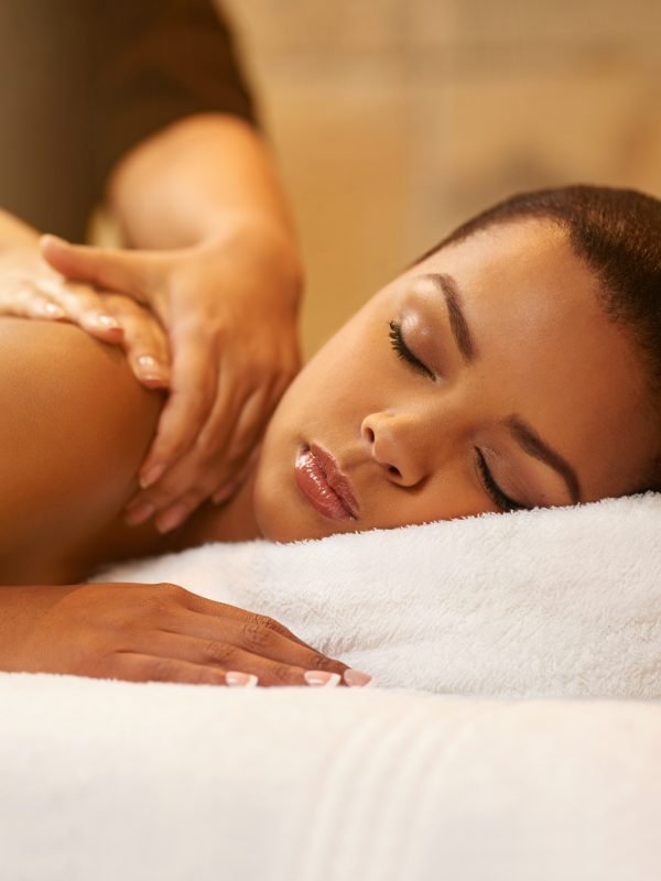 Neck, massage and girl relax in spa on table with peace, wellness and luxury treatment. Masseuse, hands and calm woman rest on holiday or client on vacation in hotel with cosmetic service and care.